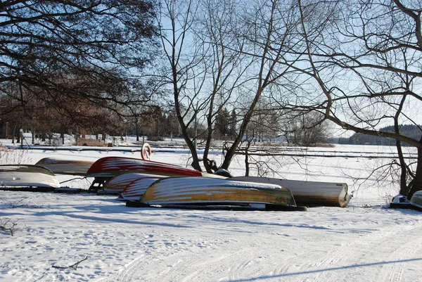 Boats on a snowy shore by a lake in Sweden — Stock Photo, Image