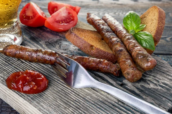 Sausages with tomatos and beer close-up