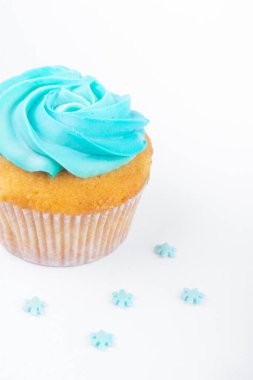 Mavi tereyağlı kremalı ev yapımı kek ve beyaz arka planda izole kar taneleri, Noel tebrik kartı.