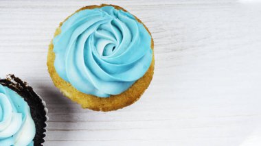 İki ev yapımı kek ya da beyaz ahşap arka planda mavi tereyağlı kek.