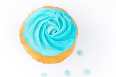 Mavi tereyağlı kremalı ev yapımı kek ve beyaz arka planda izole kar taneleri, Noel tebrik kartı.