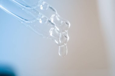 Oksijen kabarcıkları, laboratuvardaki sudaki hyaluronik asit dijital mikroskop ekranında. Susuzluk ve nemlendirici cilt konsepti. Pipetli kozmetik serumu. Seçici odak