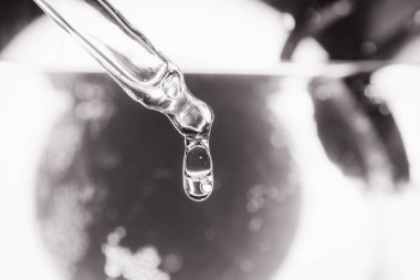 Oksijen kabarcıkları, laboratuvardaki sudaki hyaluronik asit dijital mikroskop ekranında. Susuzluk ve nemlendirici cilt konsepti. Pipetli kozmetik serumu. Tek renkli olsun. Seçici odak