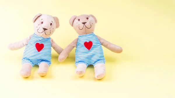 Loving happy two bear couple toy in singlet, with red heart, symbol of love and relationship Valentines Day concept, hugging, romantic style. Creative greeting card on yellow background