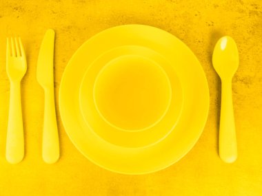 piknik sarı çatal bıçak takımları, tabaklar, bardaklar, çatal, kaşık ve bıçak aydınlatıcı arka planda