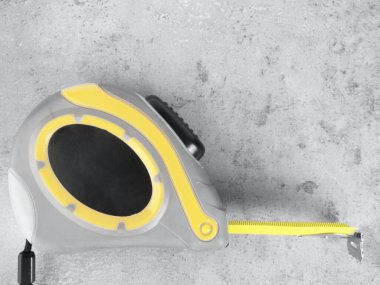 Nihai gri beton zemin üzerinde sarı bant ölçüsü, santimetre veya inç şeklinde sayısal göstergeler, kopyalama alanı, üst görünüm