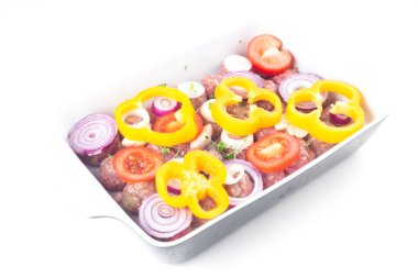 Ev yapımı çiğ organik kıymalı köfteler soğan, sarımsak, mikro yeşiller, dolmalık biber, domates dilimleri, pişmemiş, beyaz üzerine izole edilmiş, yakın çekim. Çin yemeği. Makro