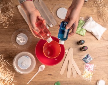 Çocuk elleri evde sümüklü oyuncak yapıyor. Sümük yapıyorum. Malzemeler ve bileşenler karıştırılır, çocukların yaratıcılığı kapalı alanda tatil yapar