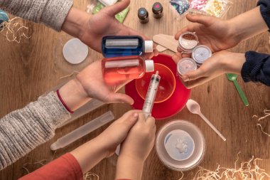 Çocuk elleri evde sümüklü oyuncak yapıyor. Sümük yapıyorum. Malzemeler ve bileşenler karıştırılır, çocukların yaratıcılığı kapalı alanda tatil yapar