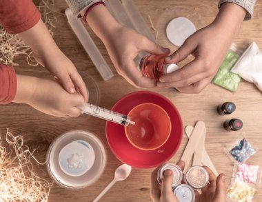 Çocuk elleri evde sümüklü oyuncak yapıyor. Sümük yapıyorum. Malzemeler ve bileşenler karıştırılır, çocukların yaratıcılığı kapalı alanda tatil yapar