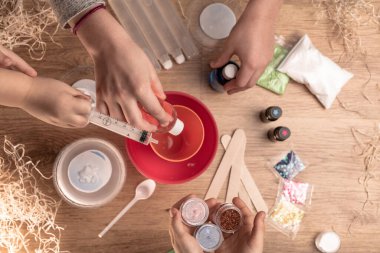 Çocuk elleri evde sümüklü oyuncak yapıyor. Sümük yapıyorum. Malzemeler ve bileşenler karıştırılır, çocukların yaratıcılığı kapalı alanda tatil yapar