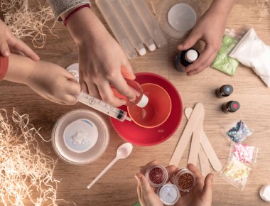 Çocuk elleri evde sümüklü oyuncak yapıyor. Sümük yapıyorum. Malzemeler ve bileşenler karıştırılır, çocukların yaratıcılığı kapalı alanda tatil yapar