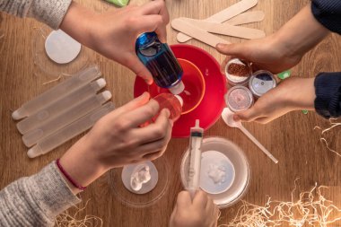 Çocuk elleri evde sümüklü oyuncak yapıyor. Sümük yapıyorum. Malzemeler ve bileşenler karıştırılır, çocukların yaratıcılığı kapalı alanda tatil yapar