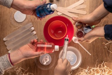 Çocuk elleri evde sümüklü oyuncak yapıyor. Sümük yapıyorum. Malzemeler ve bileşenler karıştırılır, çocukların yaratıcılığı kapalı alanda tatil yapar