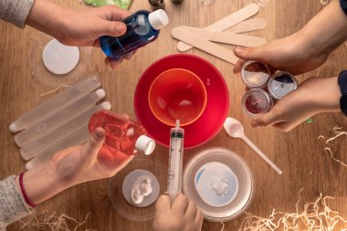 Çocuk elleri evde sümüklü oyuncak yapıyor. Sümük yapıyorum. Malzemeler ve bileşenler karıştırılır, çocukların yaratıcılığı kapalı alanda tatil yapar