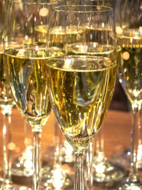 Bayram ortamlarında kutlama, kutlama, tezahürat ve parti konseptiyle bir sürü şampanya kadehi yakın plan. Seçici odak