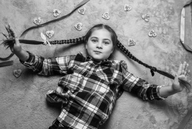 Gri halıda tatlı kalp kurabiyeleriyle uzanan komik örgülü güzel güzel kız portresi. Sevgililer Günü ya da doğum günü konsepti