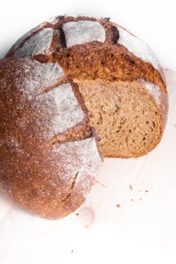 Tahta tahtada dilimlenmiş taze pişmiş kepekli ekmek, yuvarlak geleneksel lezzetli ekmek.