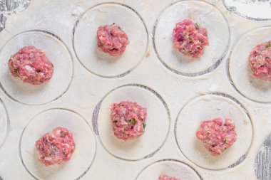 Ev yapımı etli börek ya da etli ravioli. Geleneksel Rus ulusal pelmeni yemeği. Undan yapılma hamur ve camdan yapılma daireler, kapat.