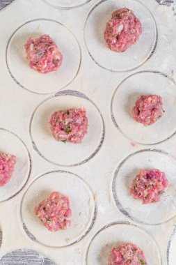Ev yapımı etli börek ya da etli ravioli. Geleneksel Rus ulusal pelmeni yemeği. Undan yapılma hamur ve camdan yapılma daireler, kapat.