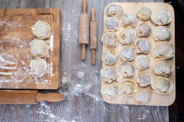 Hamur köftesi pişirmek için ham malzemeler, ahşap tahtada ravioli, hamur köftesi tarifi, un pişirme süreci. Geleneksel Rus pelmeni, et, biber, soğan, un, küf. Üst Manzara. Düz konum