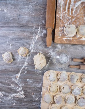Hamur köftesi pişirmek için ham malzemeler, ahşap tahtada ravioli, hamur köftesi tarifi, un pişirme süreci. Geleneksel Rus pelmeni, et, biber, soğan, un, küf. Üst Manzara. Düz konum