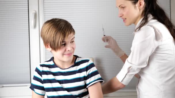 Doctor giving injection in arm to boy — Stock Video