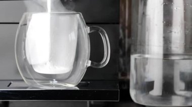 Makine aktif olarak kapuçino yapmak için çırpılmış krema serpiyor.