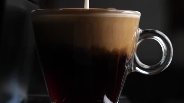 Lägga till mjölk till en kopp svart kaffe i slow motion — Stockvideo
