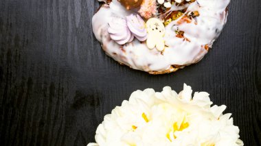 Paskalya pastası, dekoratif çikolata tavşanı, ahşap masada narsist çiçek.