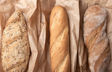 Taze pişmiş lezzetli ekmek, ciabatta. Ev yapımı çeşitli baget ekmeği, tam buğday, yulaf ve çavdar ekmeği. Sağlıklı yaşam tarzı, çoklu tohum, kağıt torbalarda glütensiz fırınlanmış ekmek. Kapat..