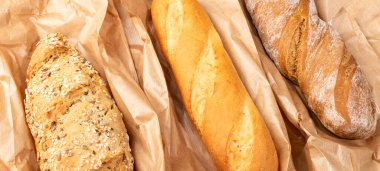 Taze pişmiş lezzetli ekmek, ciabatta. Ev yapımı çeşitli baget ekmeği, tam buğday, yulaf ve çavdar ekmeği. Sağlıklı yaşam tarzı, çoklu tohum, kağıt torbalarda glütensiz fırınlanmış ekmek. Kapat..