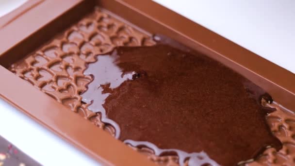 Versando il cioccolato nello stampo a forma di cuore — Video Stock
