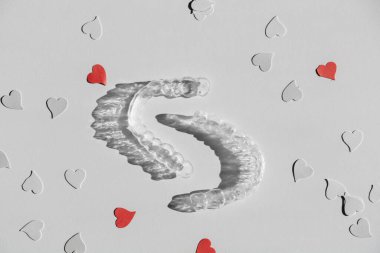 Şeffaf diş telleri. Kağıt kalplerle hizalandıktan sonra dişleri düzeltmek için görünmez hizalayıcılar, boşluğu kopyala