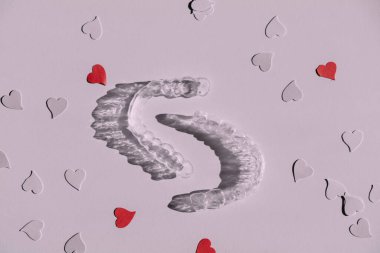 Şeffaf diş telleri. Kağıt kalplerle hizalandıktan sonra dişleri düzeltmek için görünmez hizalayıcılar, kopyalama alanı. Yaratıcı tonlama