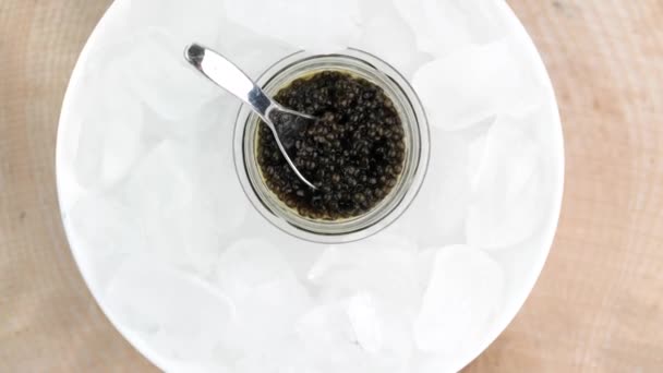 Czarny kawior w szklanym słoiku z lodem — Wideo stockowe