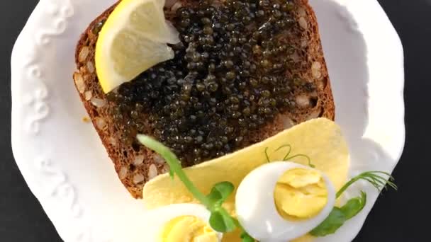 Black caviar served on bread — Stock Video