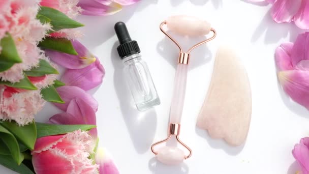 Biologische huidverzorging jade roller, gua sha, serum extract en bloemen — Stockvideo