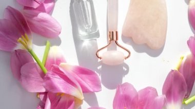 organik cilt bakımı yeşim taşı, gua sha, serum özü ve çiçekler