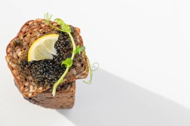 Siyah havyar, yumurtalı, limonlu, yeşillikli bir sandviç. Antioksidan açısından zengin, lezzetli yiyecekler. Seçici odaklanma. Boşluğu kopyala