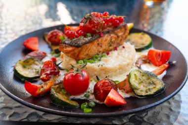 Fırında pişmiş somon bifteği, böğürtlen ve sebzeli leziz risotto. Akdeniz mutfağı, sağlıklı yiyecekler.