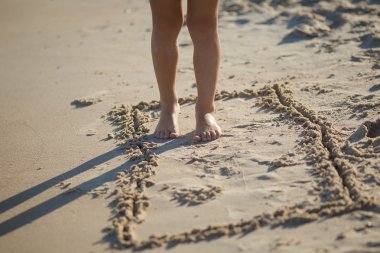 Çocuk kum plajda durup