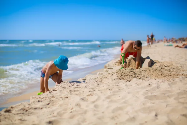 Ayah dan anak membangun istana di pasir — Stok Foto