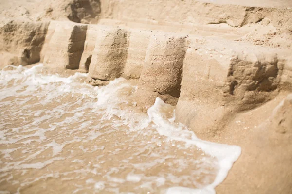 Burg aus Sand und Meereswelle — Stockfoto