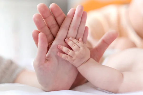 Отец и мать держат в руках руку новорожденного ребенка — стоковое фото