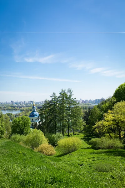 Paysage avec herbe verte, ciel bleu, église, ville — Photo