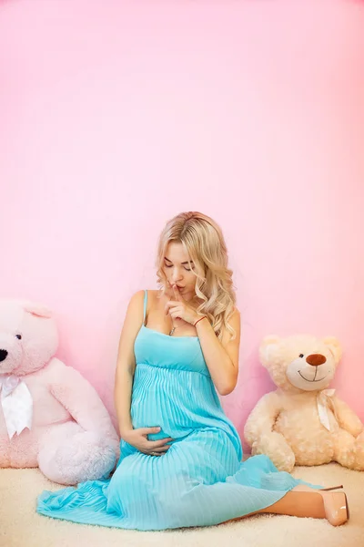 Mooie zwangere vrouw in een turquoise jurk — Stockfoto