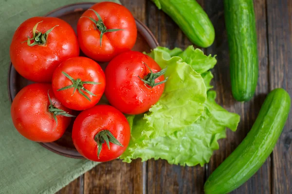Bahar sebzeler. domates, salatalık ve marul üzerine bir ahşap