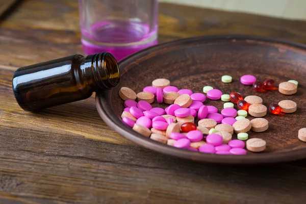 pills on a plate on a wooden background