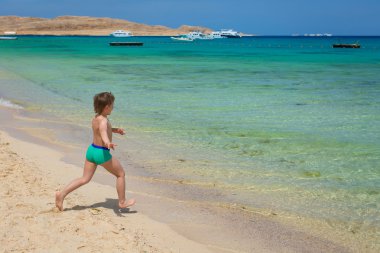 güzel, beyaz plaj mavi gökyüzü mavi denize çocuk çalışır